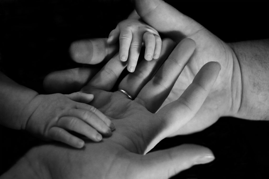 manos de padres con las de su bebé